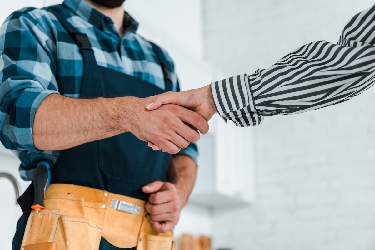 cropped view of woman shaking hands with handyman cropped view of woman shaking hands with handyman