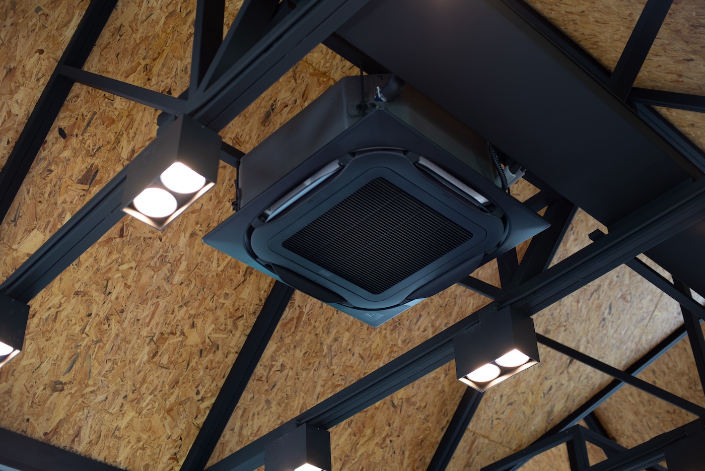 New black air conditioning vent on ceiling modern restaurant, inside background. Modern Heavy ceiling air conditioner decoration in loft style office. Cassette type air conditioner, close up