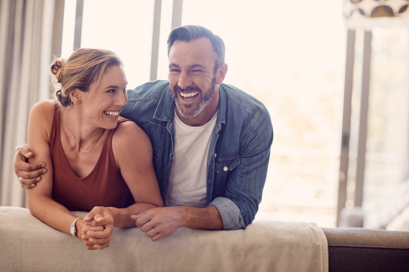 Smiling engineer shaking hands at construction site with happy architect.