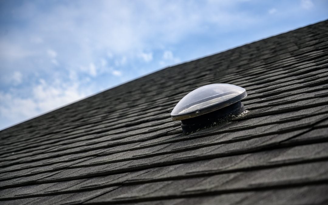 Dome shaped solar tube skylight on asphalt shingle roof