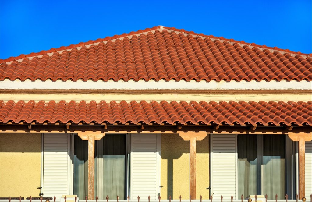 tile roof installation on yellow home