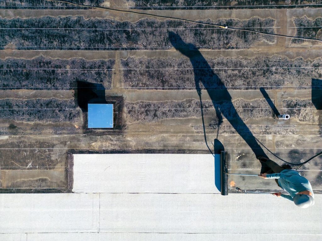 Roofer applying torch to flat roof
