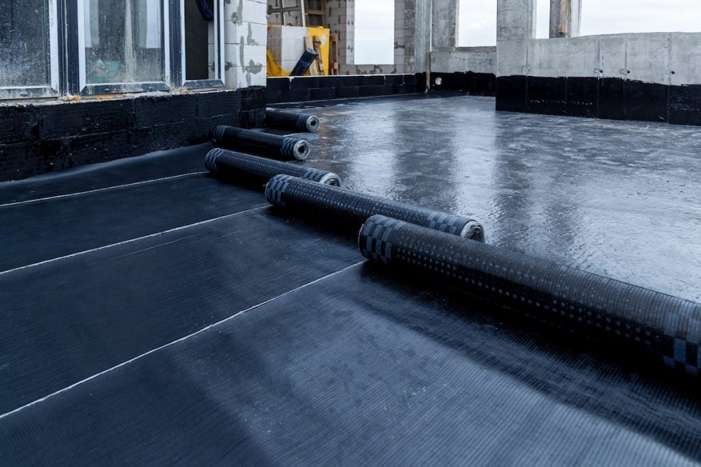 Laying and installation of roofing, bituminous waterproofing of an apartment building. Rolled roofing waterproofing of concrete slabs of stylobate. Heating and melting of bituminous roofing material.