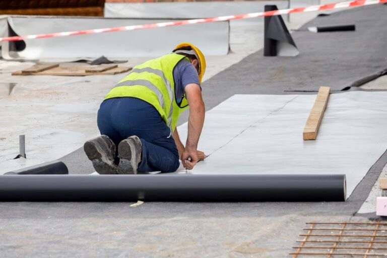 Contractor cutting roof material for a commercial roof