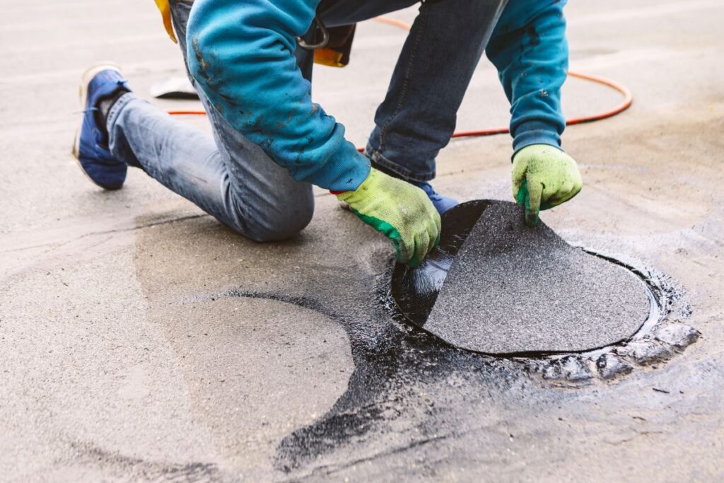 commercial roofers worker repairing roof section