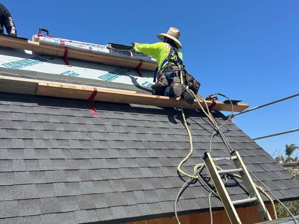 residential roofing Streamline contractors worker on top of shingles roof