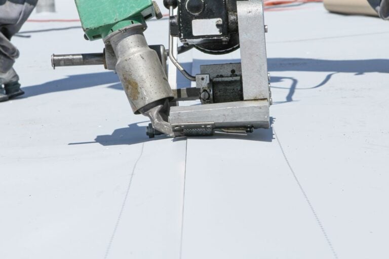 pvc roofing sheets worker applying white membrane on flat roof