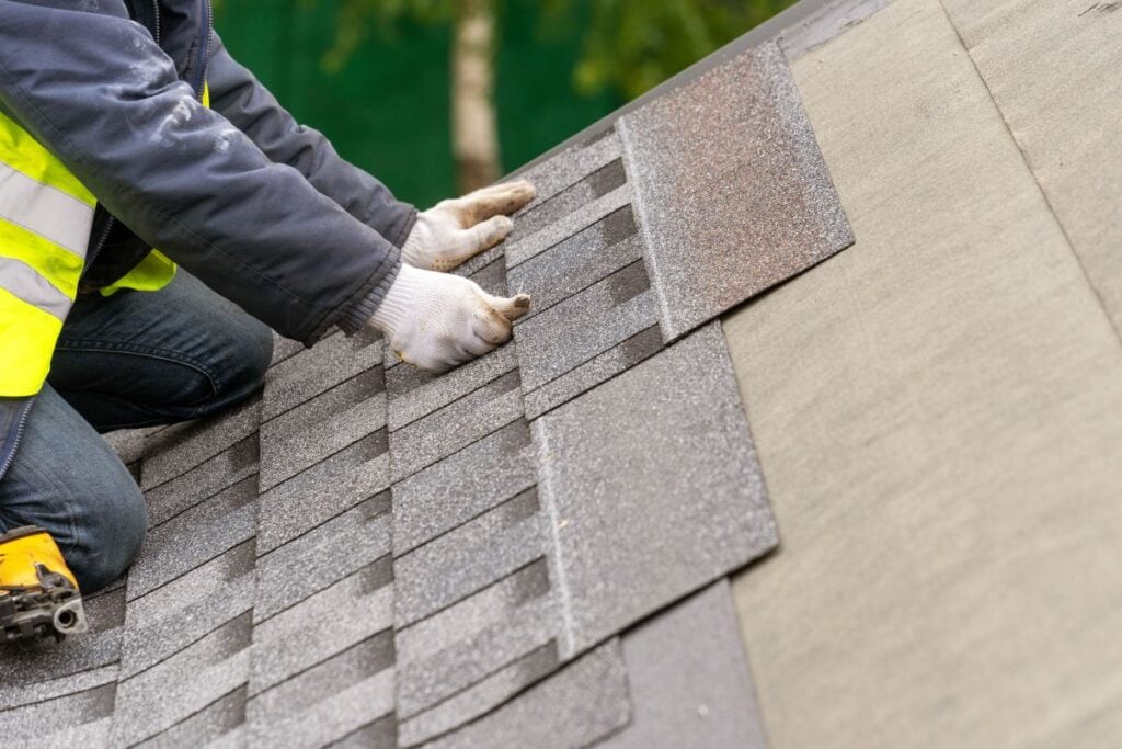 malarkey roofing products worker replacing shingles
