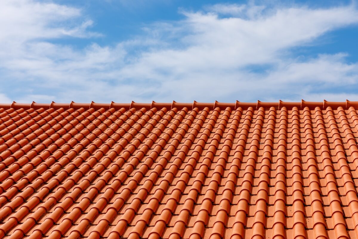 Red tiles panels roof under blue sky
