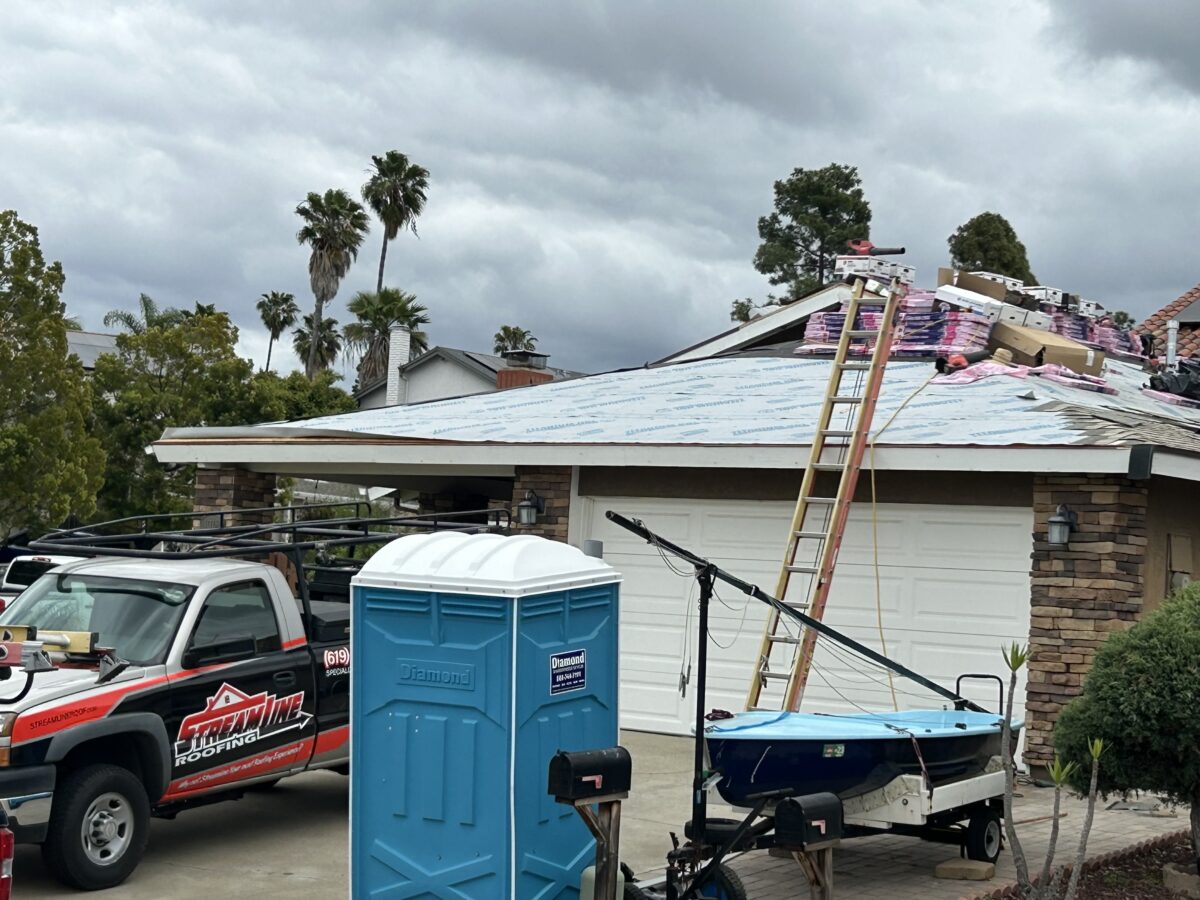 roof replacement cost workers on top of roof replacing