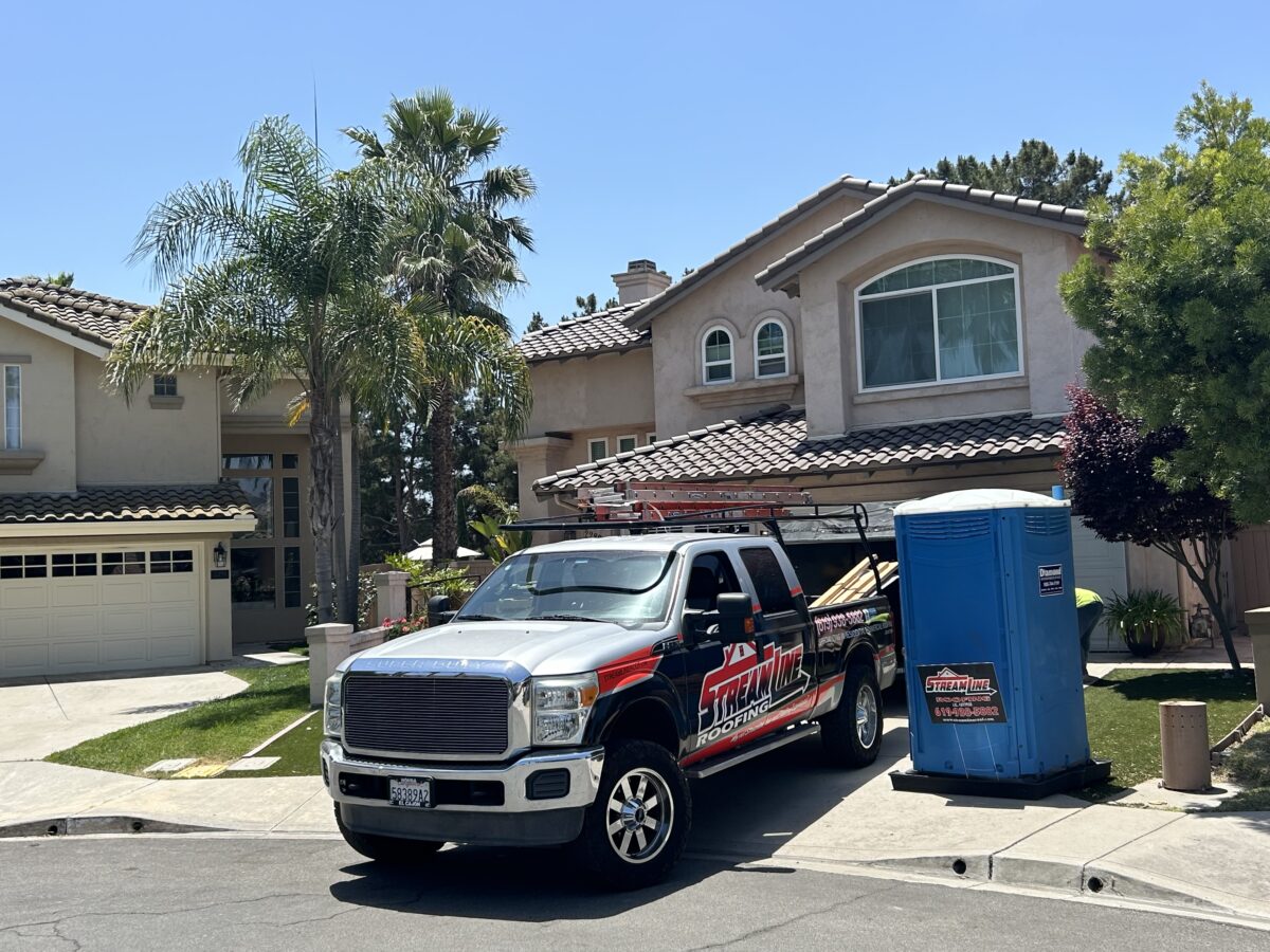 roof pitch branded truck parked outside house