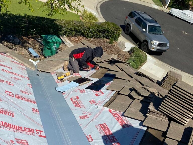 asphalt shingle roof installation worker on top of roof