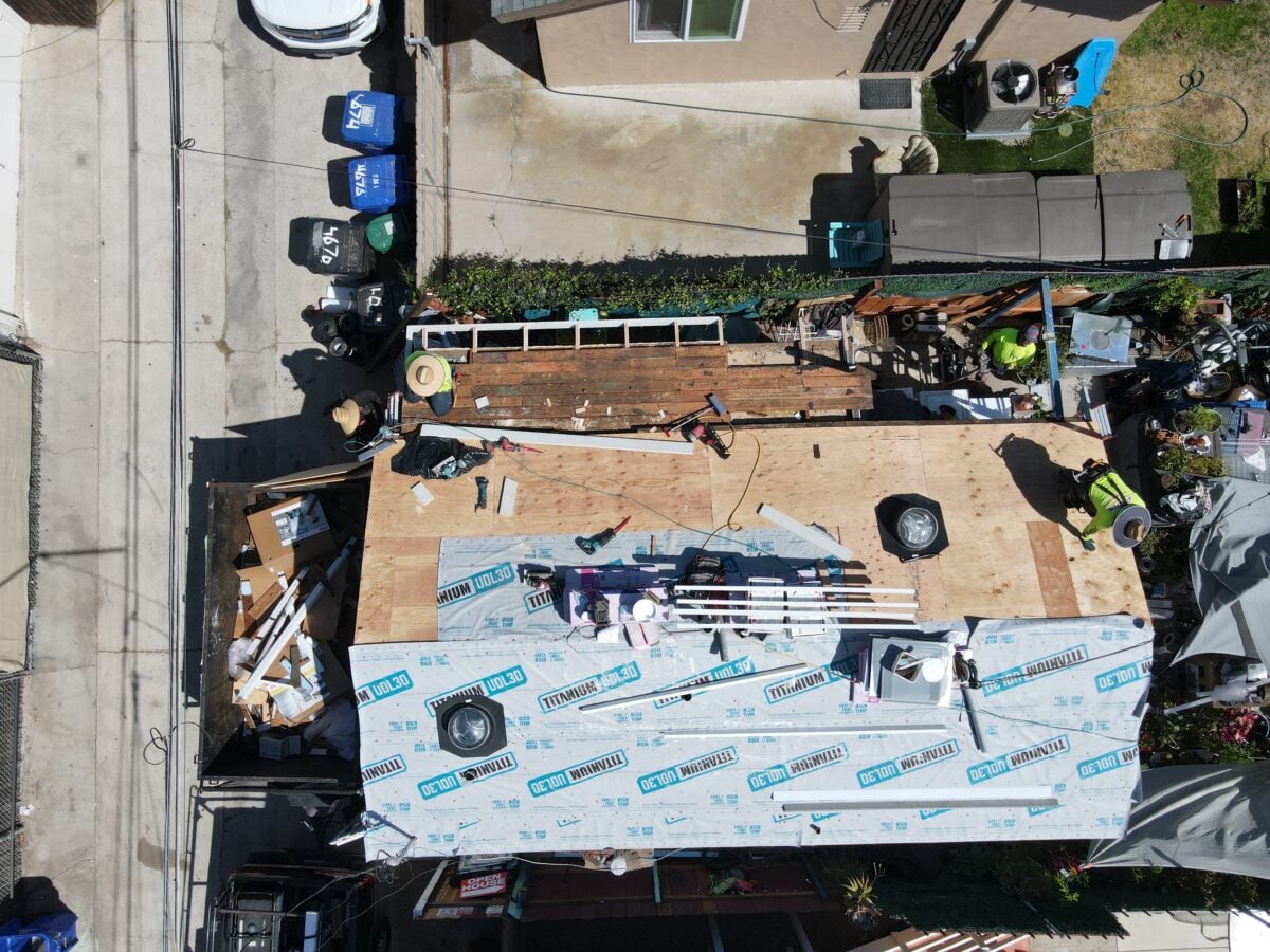asphalt shingle roof installation aerial view of workers on top of shingles roof